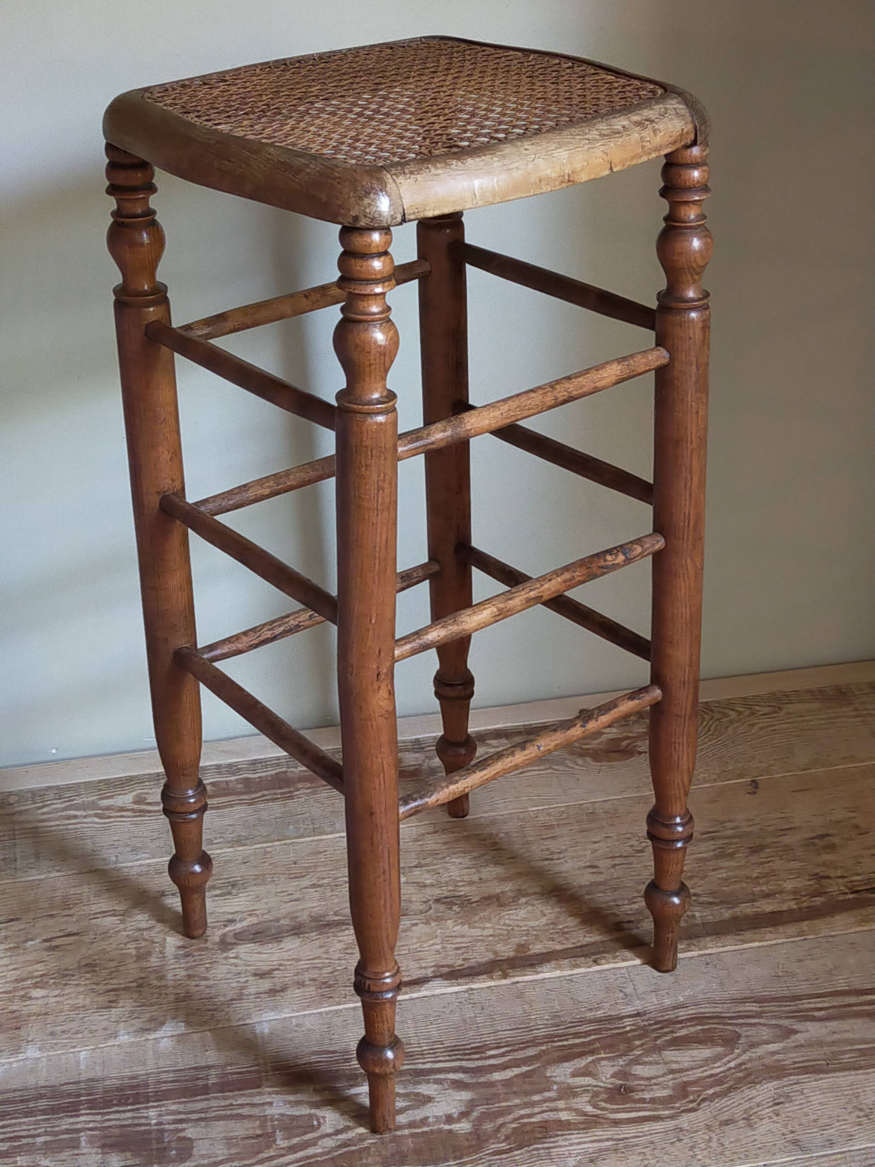 Antique stool with cane and turned wood