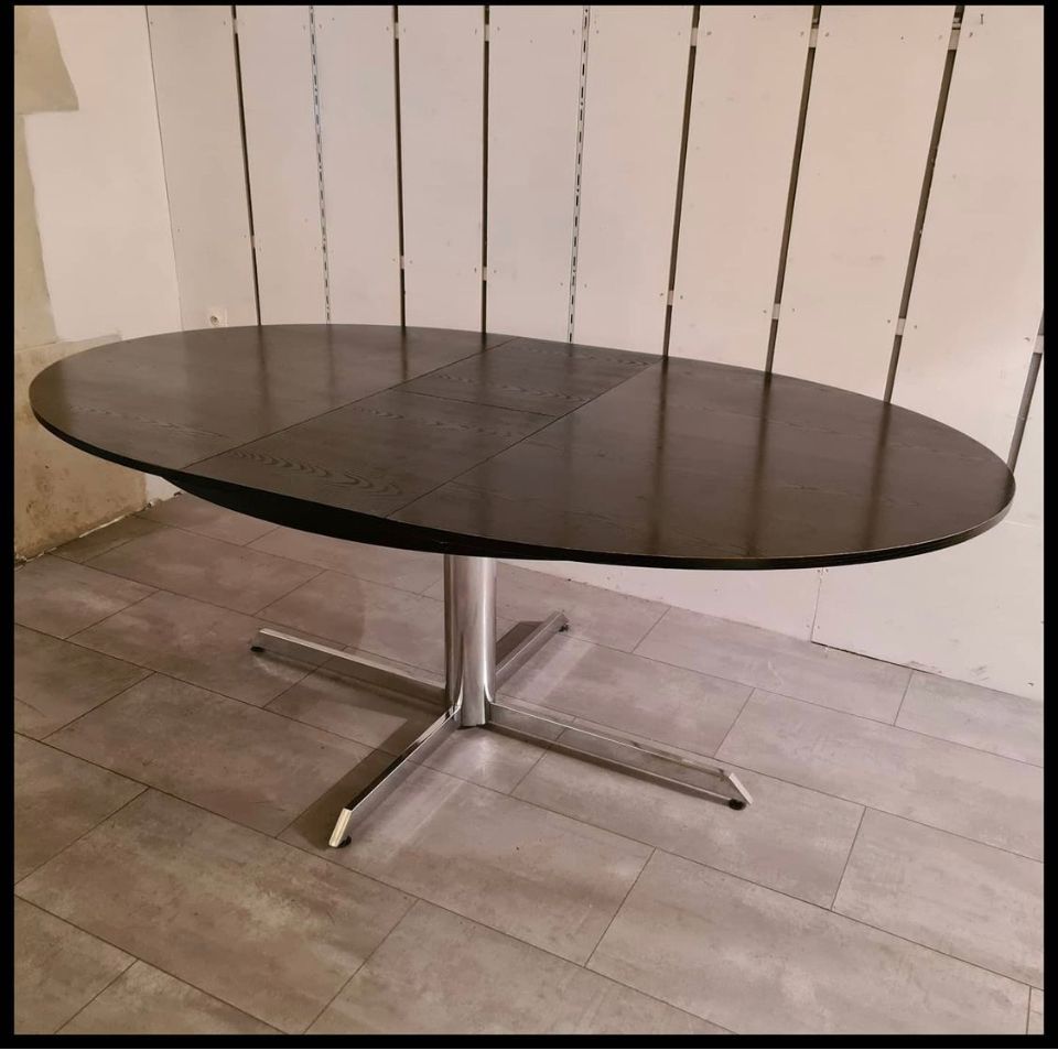 Blackened wooden dining table and chrome foot with integrated butterfly extension