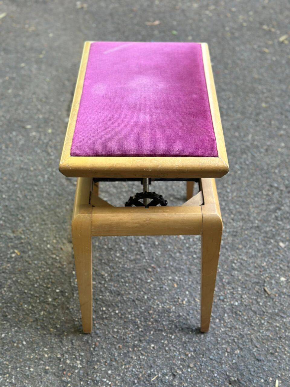 Adjustable piano stool in light beech and purple velvet.