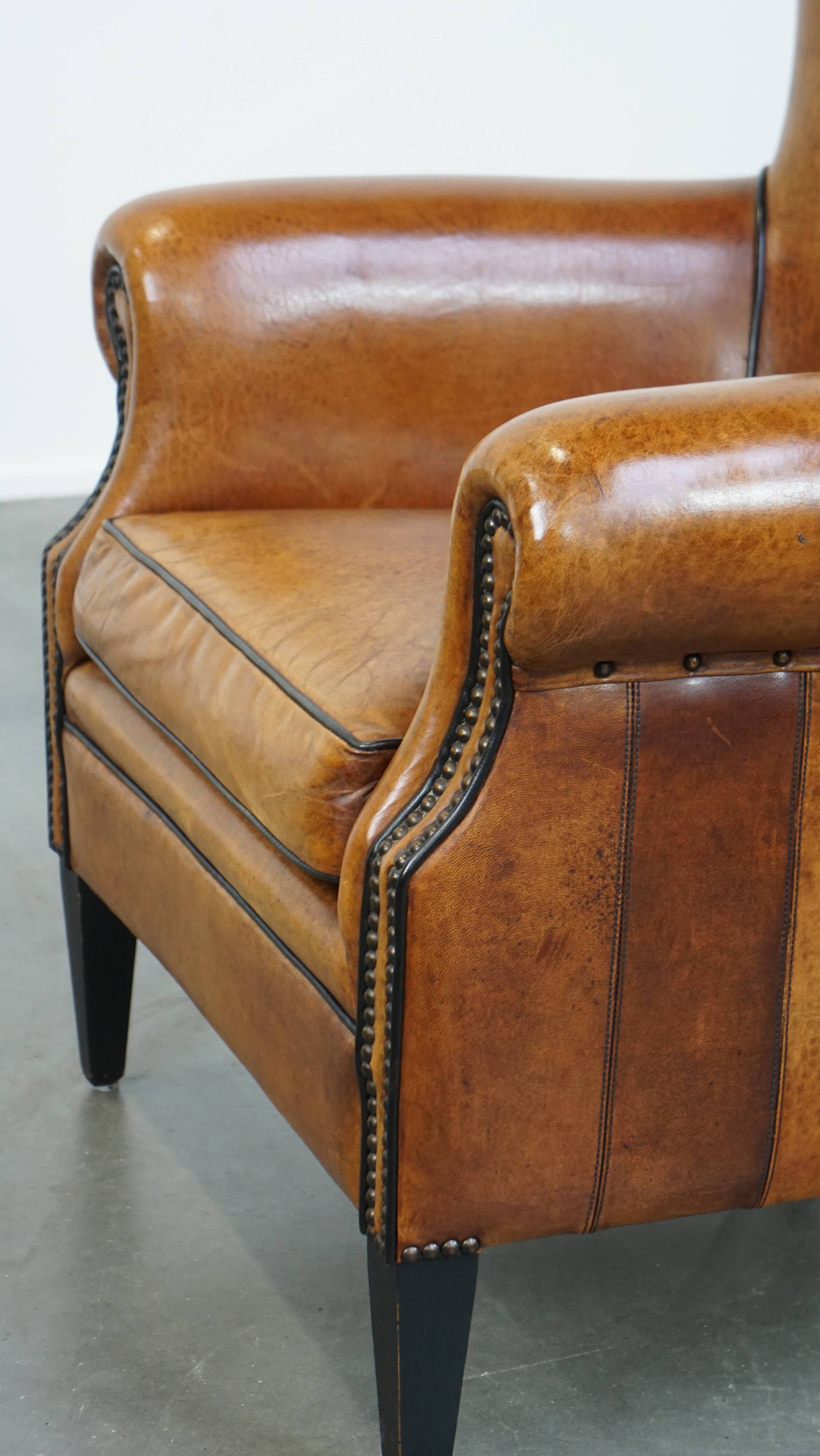 Cognac-colored sheep leather armchair finished with decorative nails