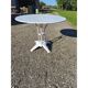 Garden table with a cast iron base and a metal top.