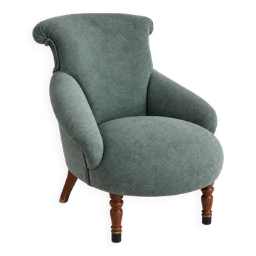Restored vintage armchair reupholstered in green fabric.