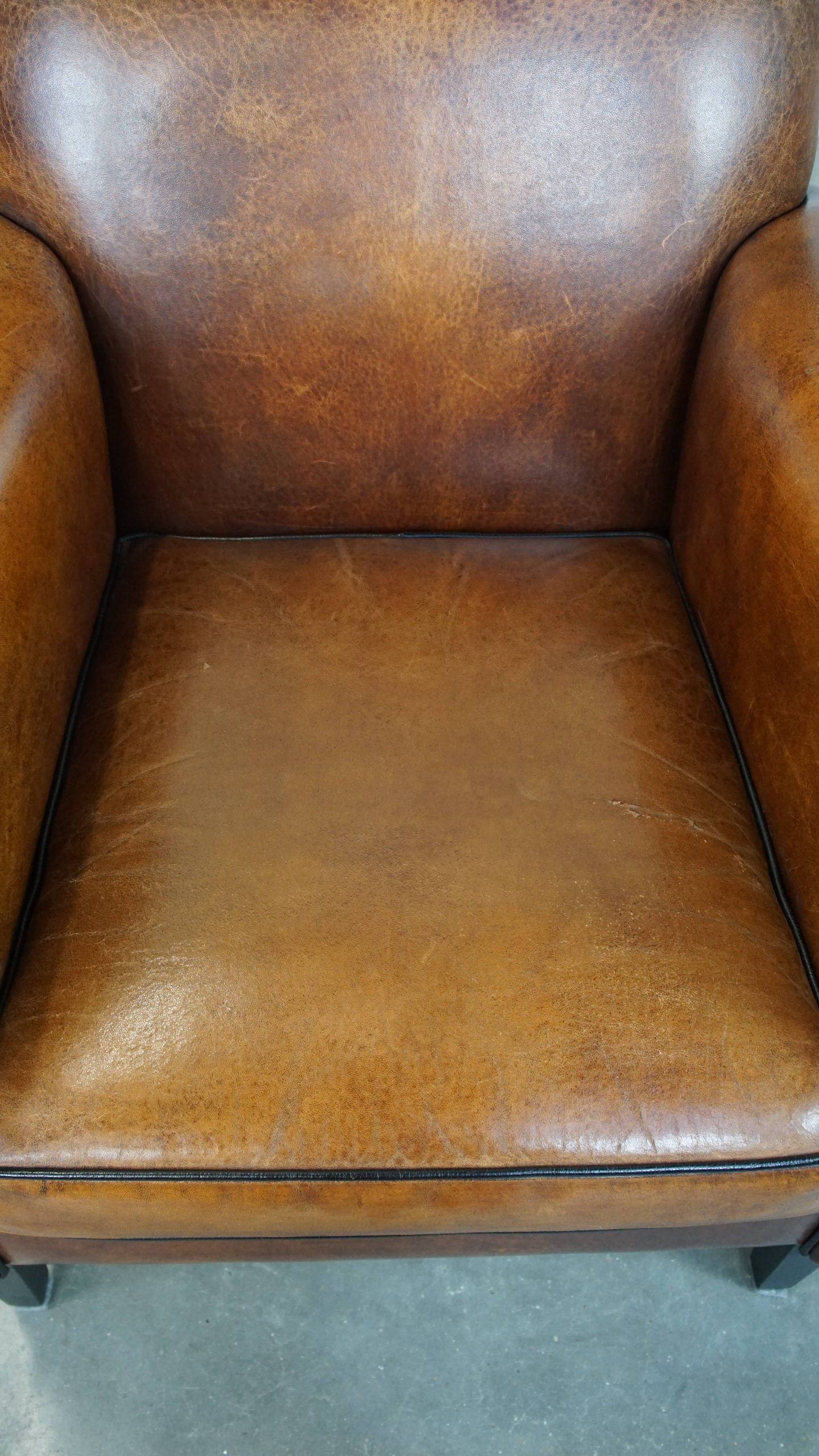 Sheepskin Art Deco design armchair with sleek finish and black piping
