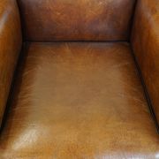 Sheepskin Art Deco design armchair with sleek finish and black piping
