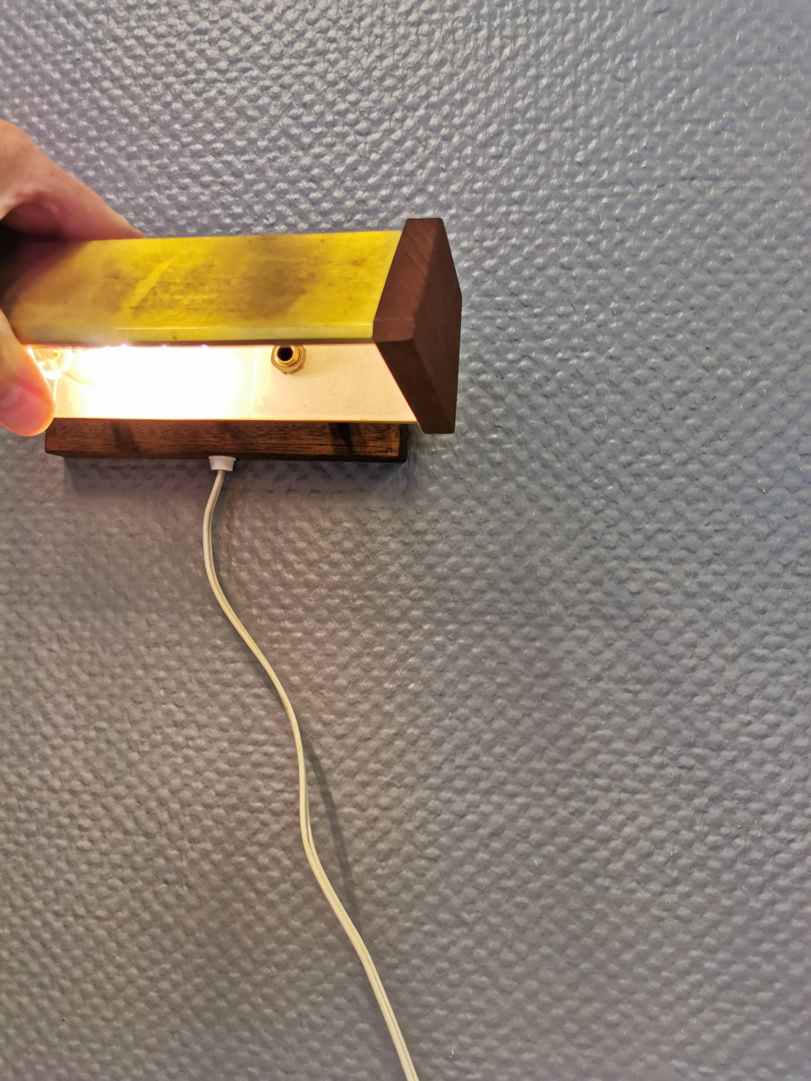 Fuga wall lamp in solid brass and teak wood was designed by Jo Hammerborg for Fog & Mørup in 1966.