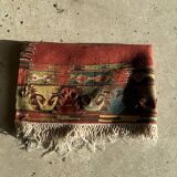 Small wool rug, predominantly red with geometric patterns