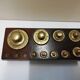 Brass weight series on wooden support