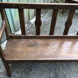 Duo of old solid oak benches with backs and armrests.