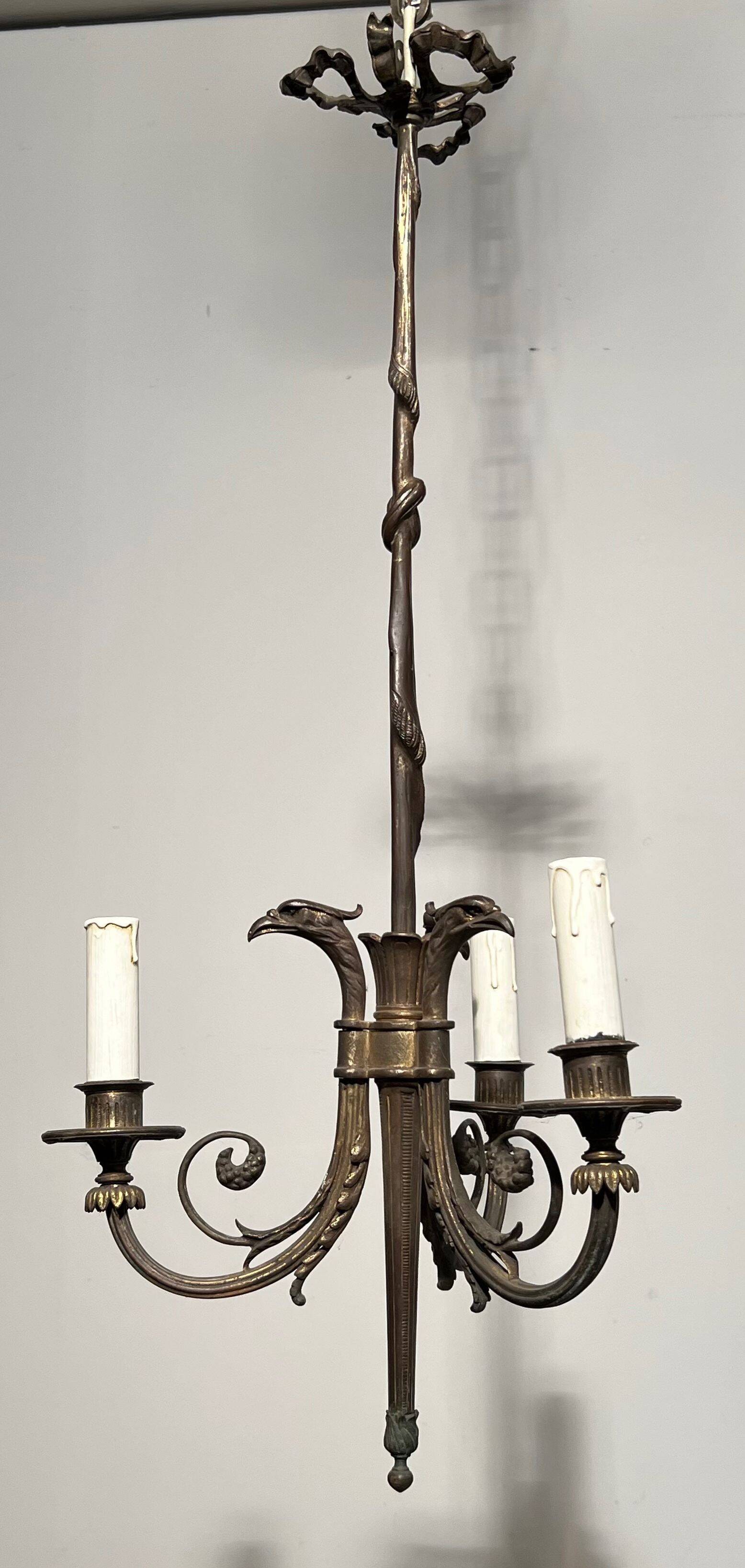 Empire-style bronze chandelier with 3 arms of light topped with eagle heads. French work. Circa 1900.