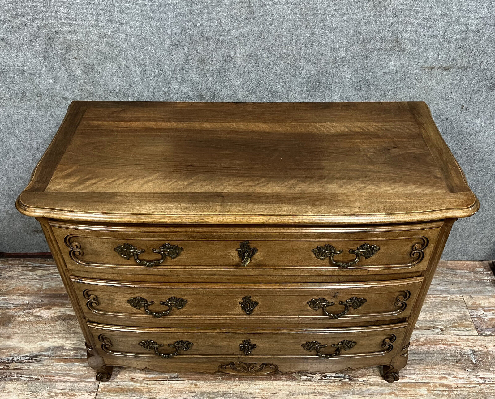 Curved Louis XV style chest of drawers in solid wood with a light patina