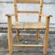 Old wooden children's armchair and vintage woven straw seat