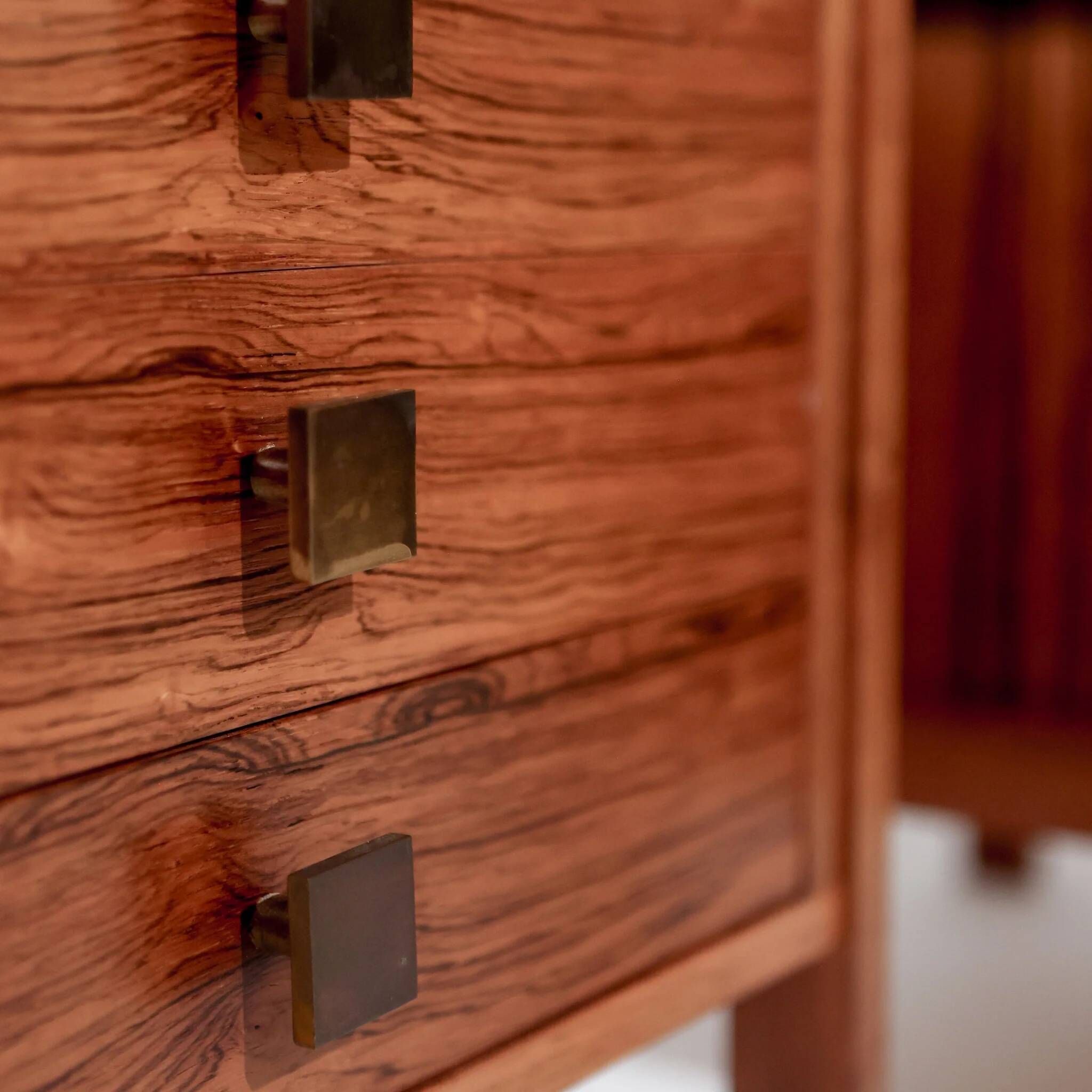 Pair of vintage Scandinavian bedside tables, three drawers, honey-toned wood.