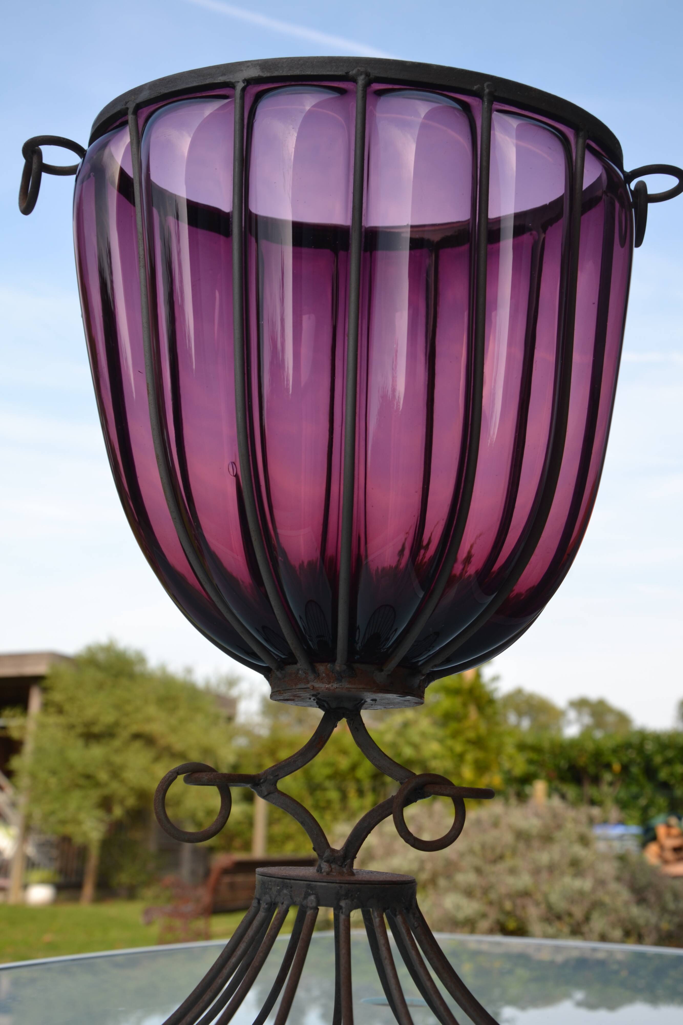 Large blown glass and wrought iron vase on shower stand