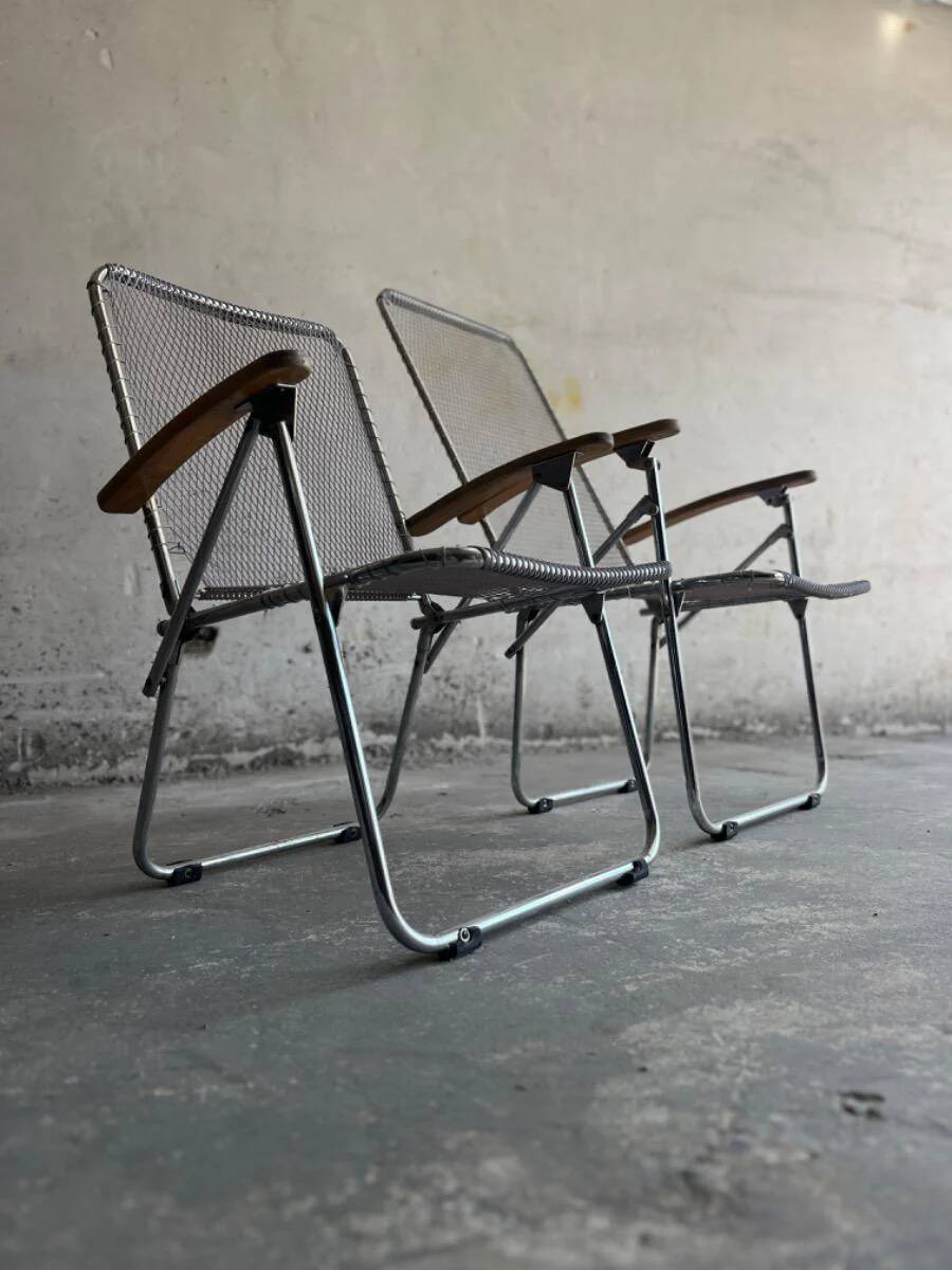 Pair of vintage silver aluminum wire folding chairs with wooden armrests — industrial minimalist