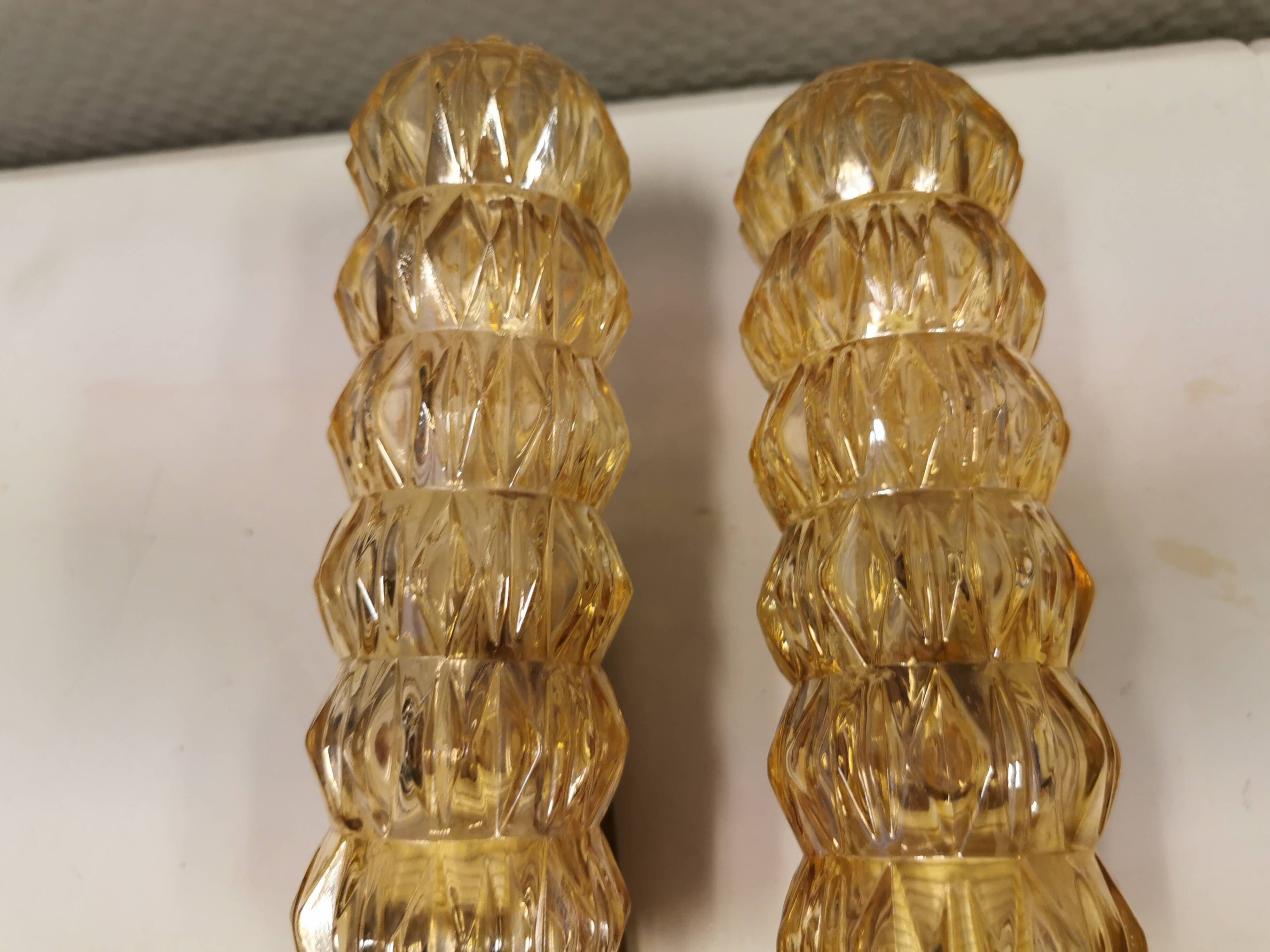A set of Danish wall lights in champagne coloured glass with brass and teak.