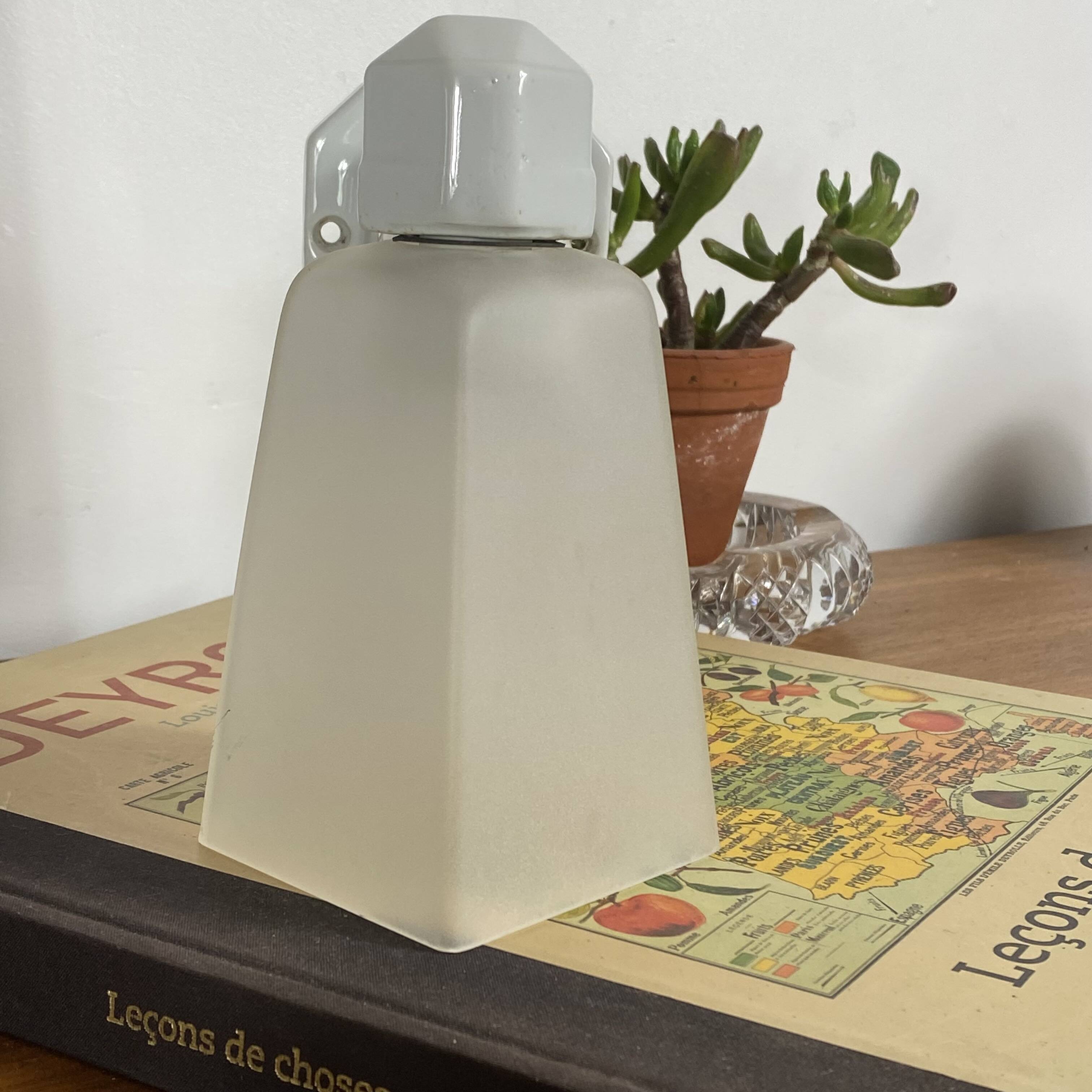 Swan neck wall light in ceramic with a translucent glass globe.