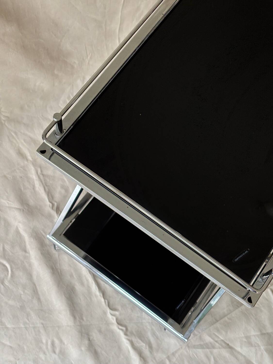 Modernist serving trolley in chromed metal and black smoked glass