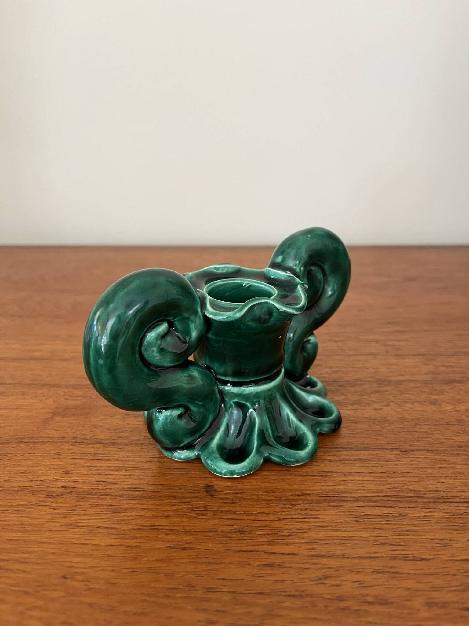 Green ceramic candlestick with curled handles.
