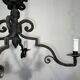Two-tiered wrought iron chandelier with eight light arms in Gothic style.