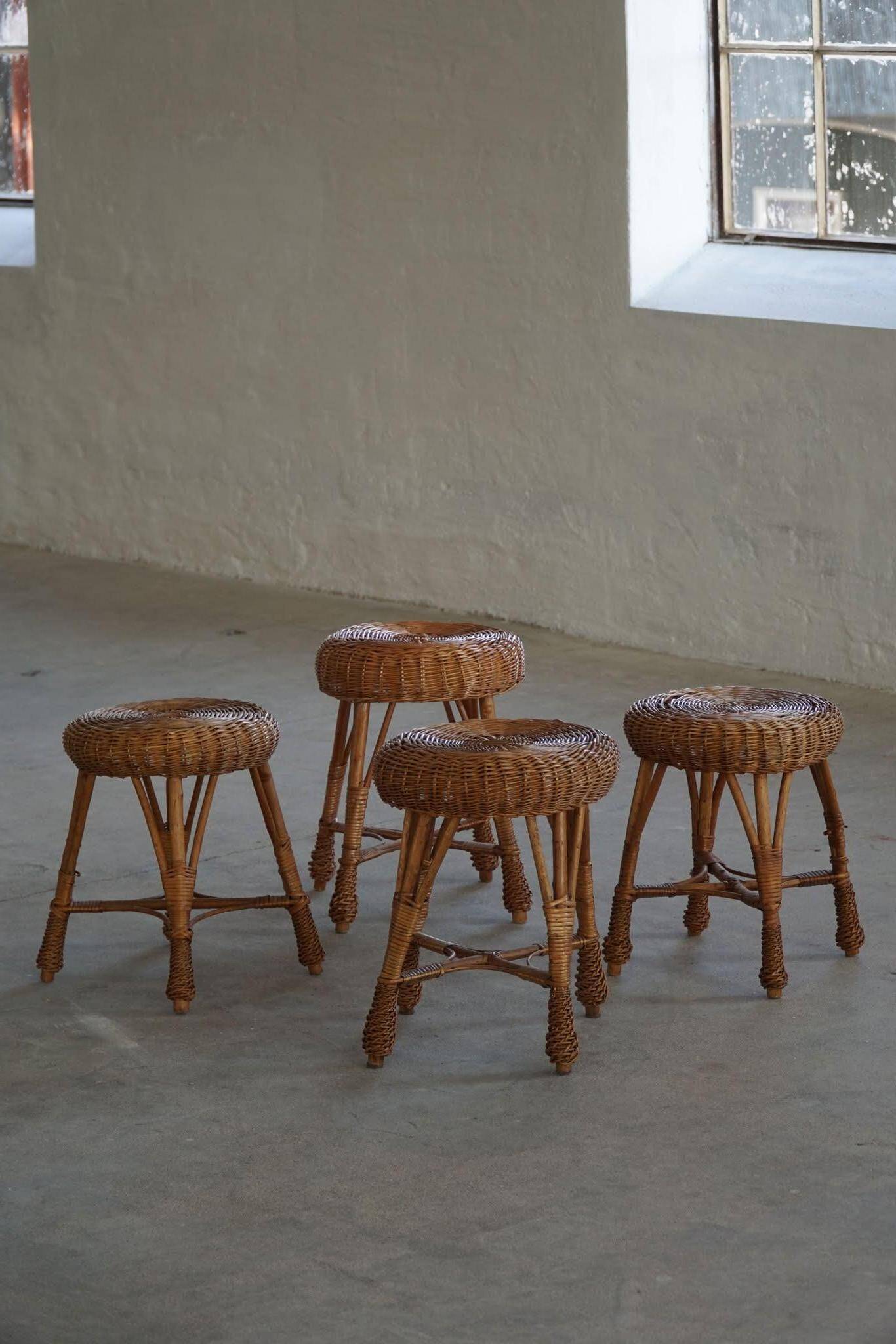 A set of 4 vintage Scandinavian rattan stools, in the style of Tony Paul, from the 1960s.