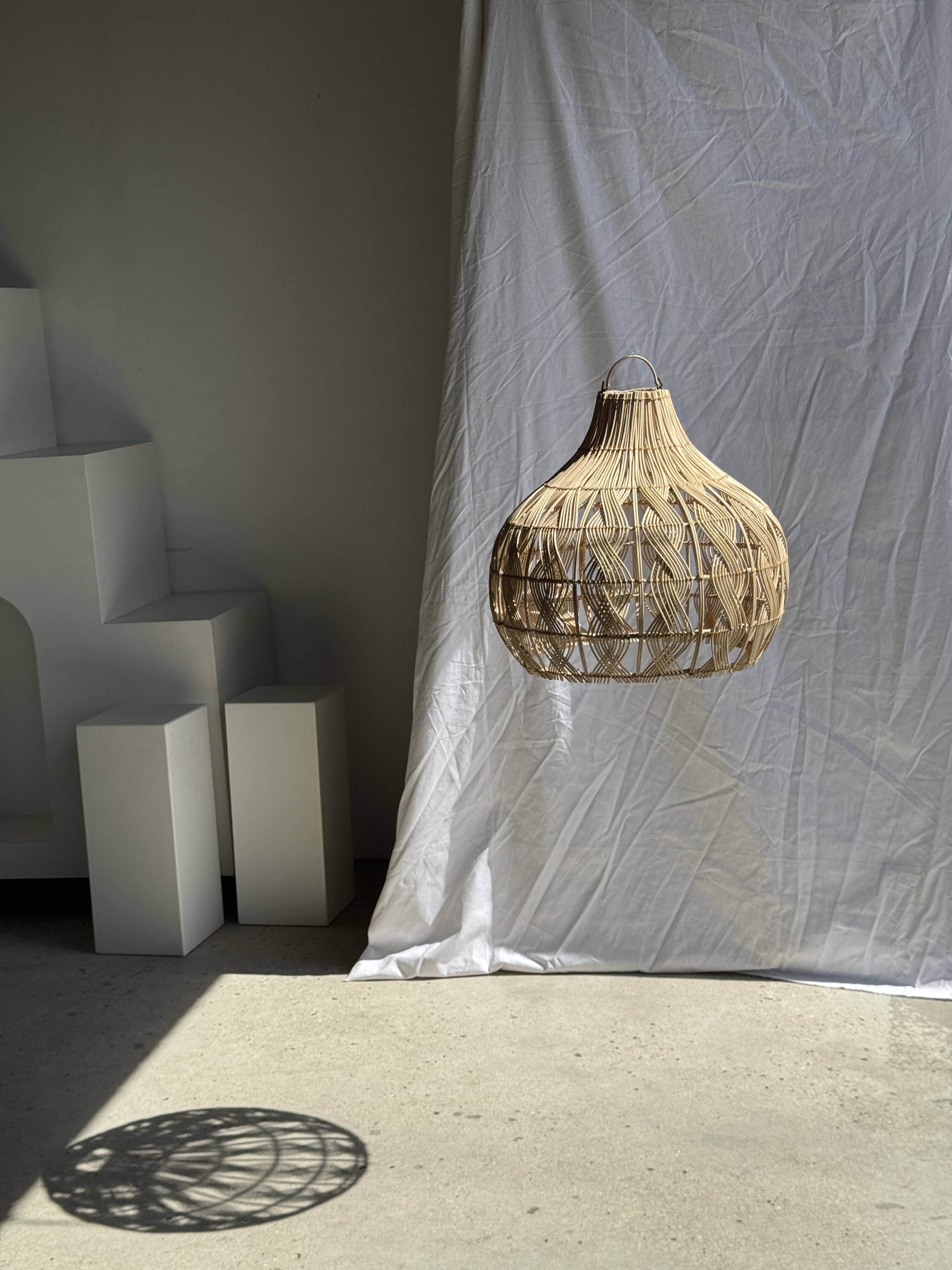 Suspension or rattan lampshade in the shape of a woven bulb.