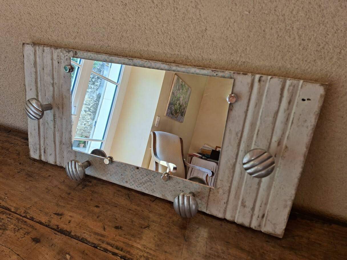 Wall-mounted coat rack with a patinated mirror