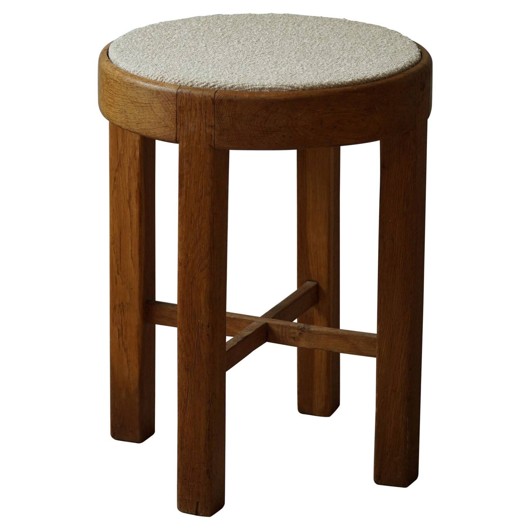 Mid-century Danish stool in oak, reupholstered in boucle wool, circa 1950.