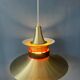 Large UFO flying saucer pendant light with orange light.