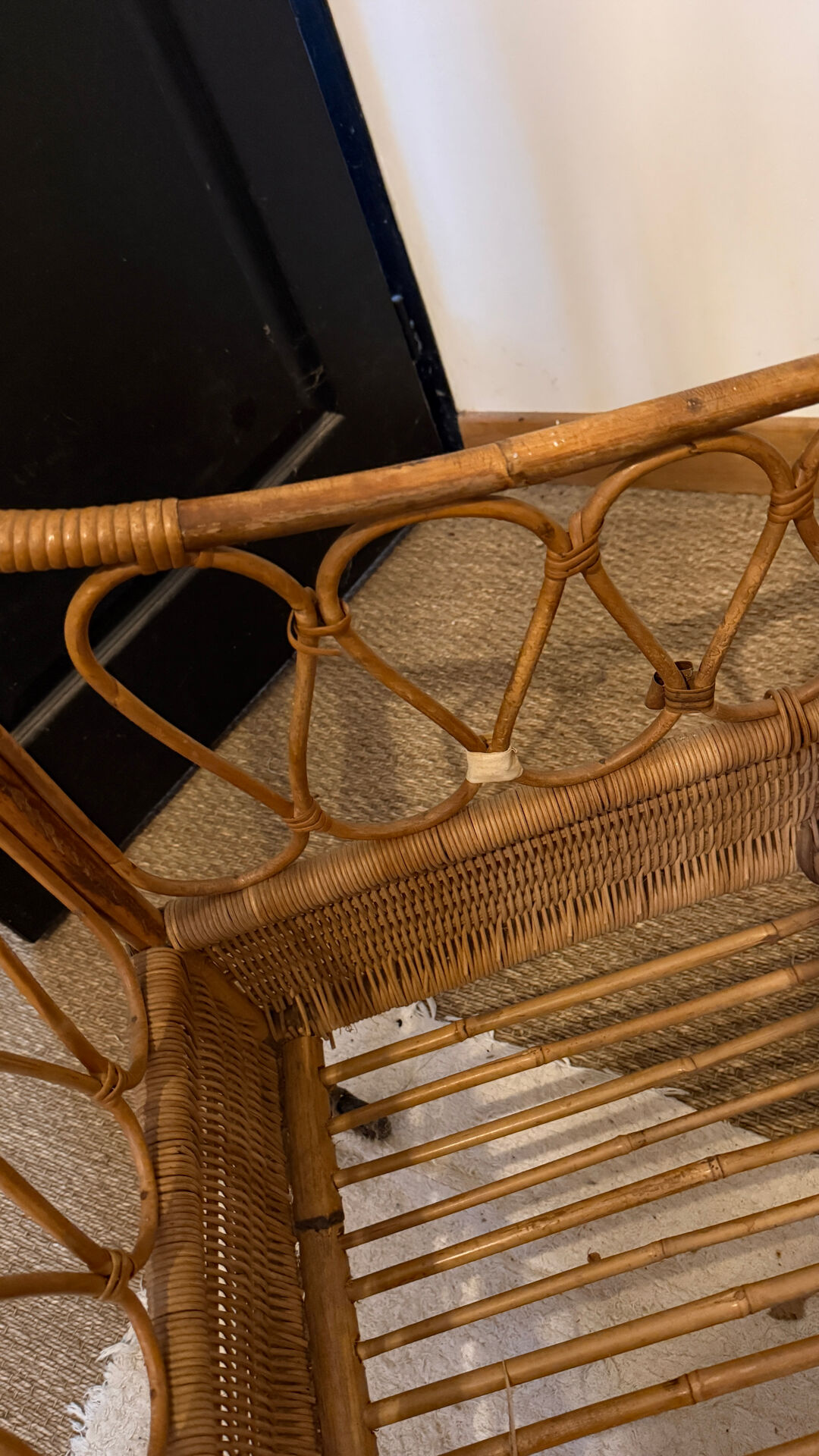 Vintage rattan baby cot on wheels.