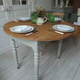 Walnut table with raised flaps, base on verdigris casters.