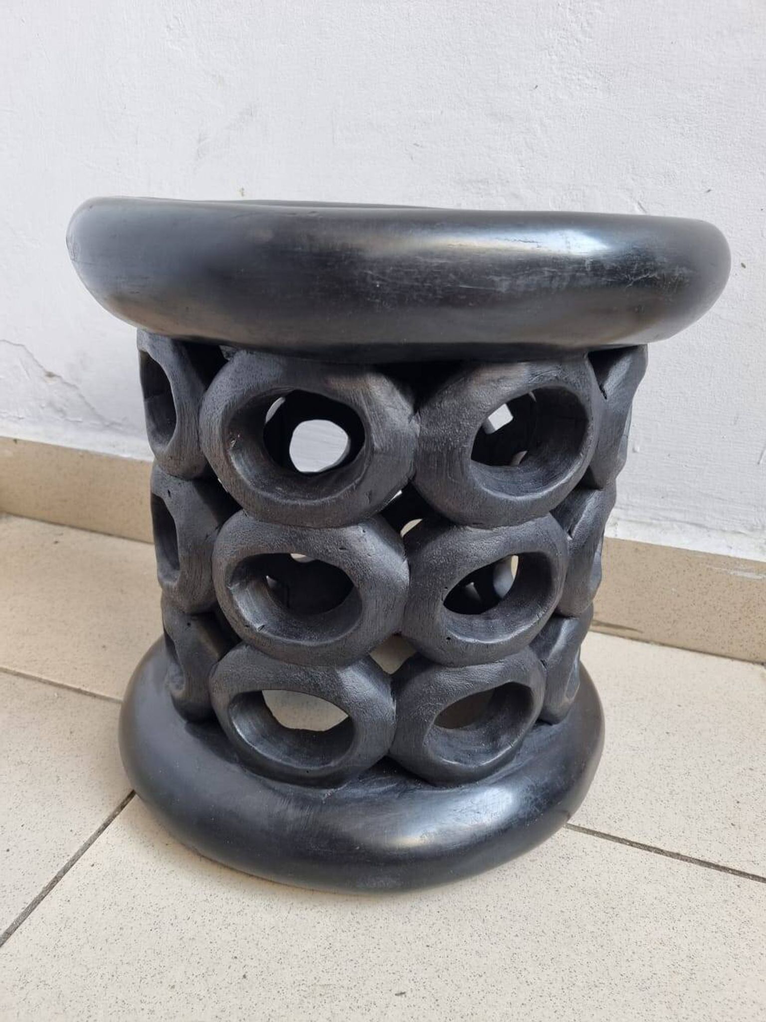 Bamiléké black stool in carved wood with rings – 33 × 35 cm