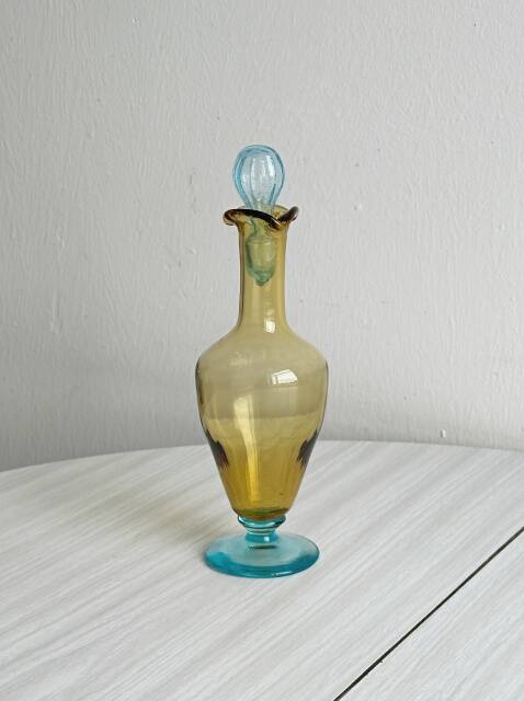 Old glass vial in yellow and blue.