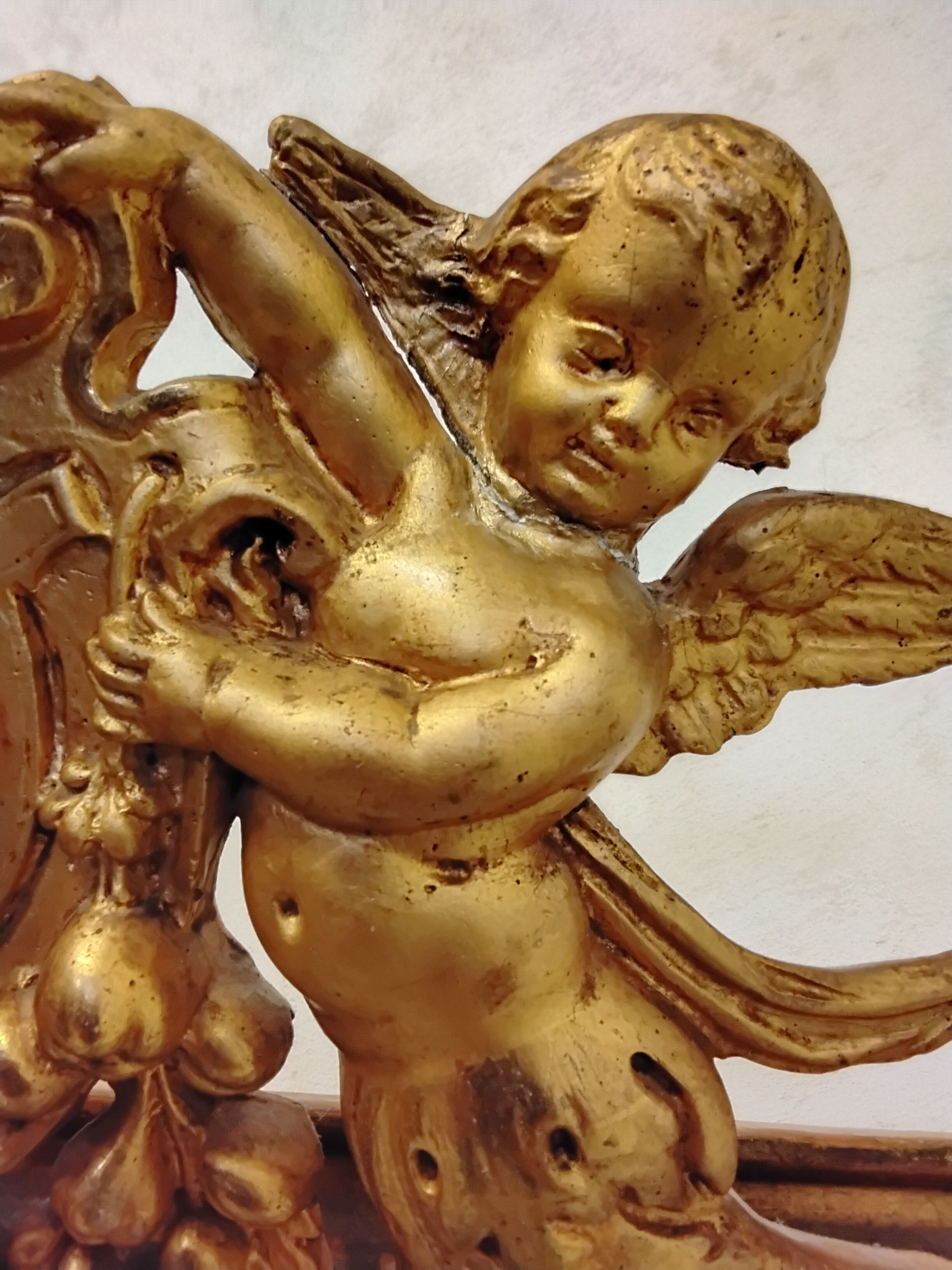 Antique mirror with a gilded frame and cherubs.