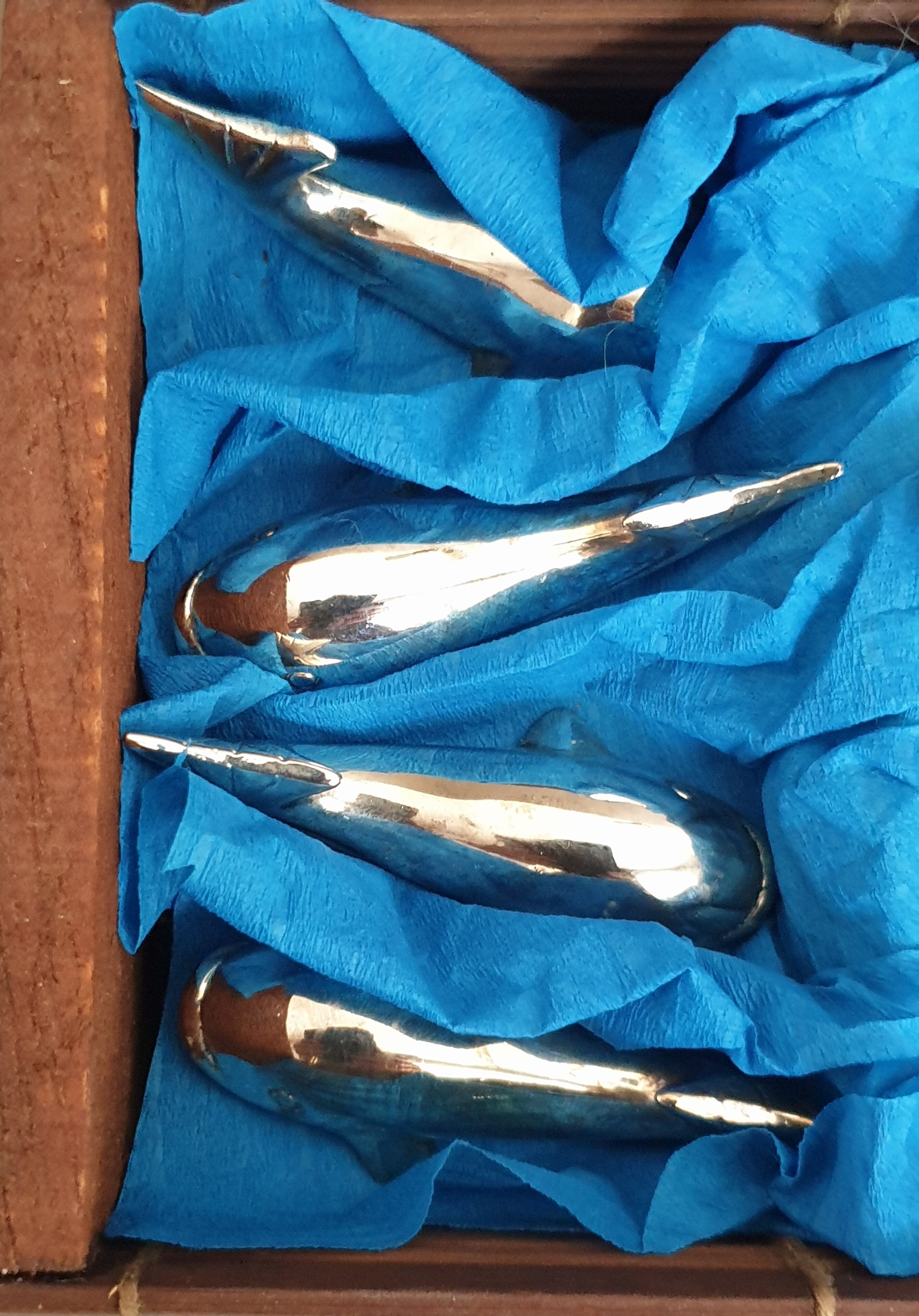 Lot 12 knife holders in the shape of a stylized whale or fish