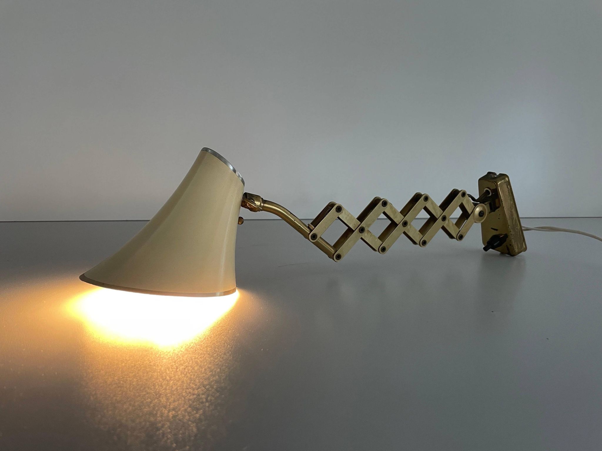 Cream metal and brass wall lamp with scissors design by Karl Lang for SIS Licht, 1950s, Germany.