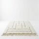 White Moroccan rug with a graphic pattern.