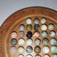 Ancient solitaire game in wood and stone marbles