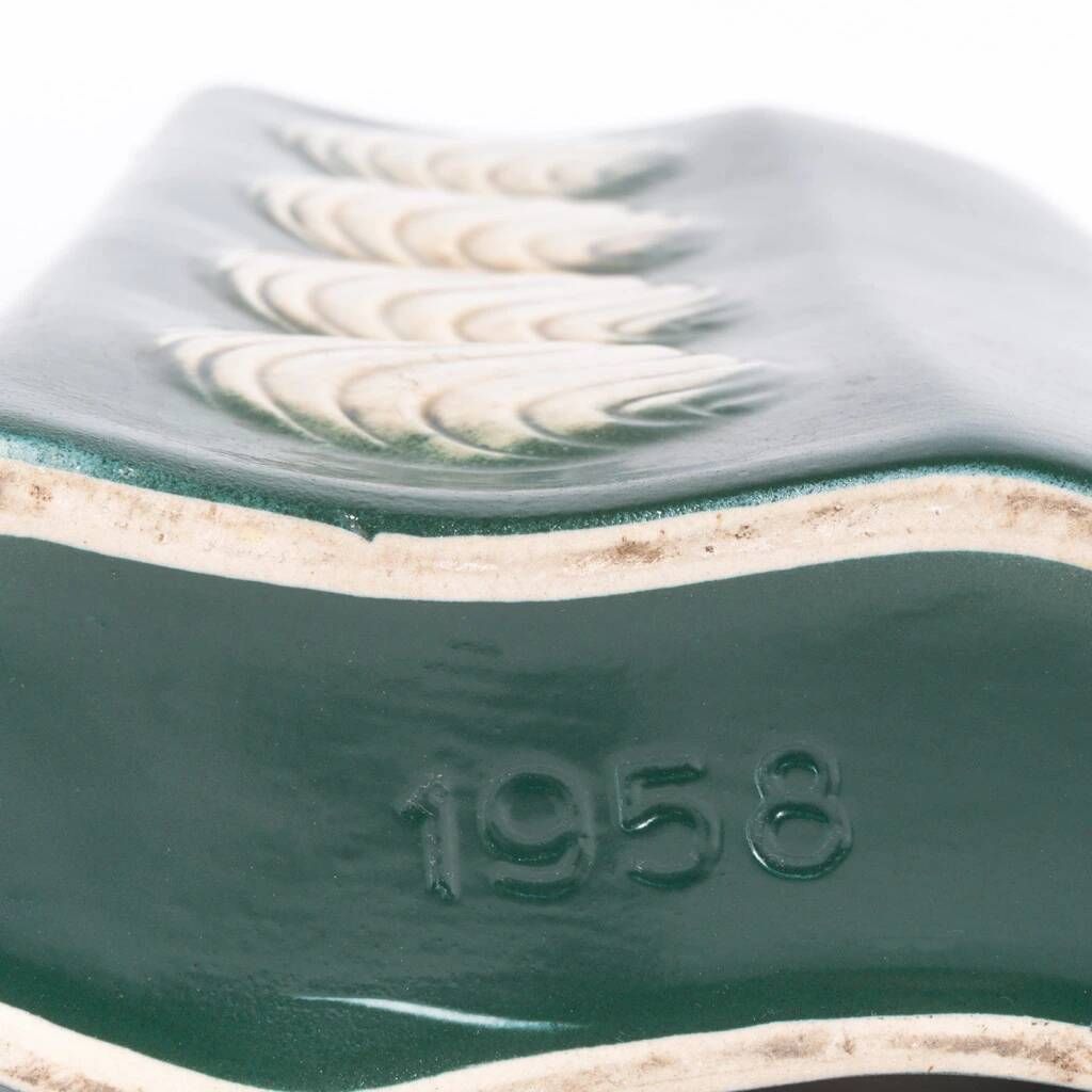 A tall ceramic vase glazed with dark green colour