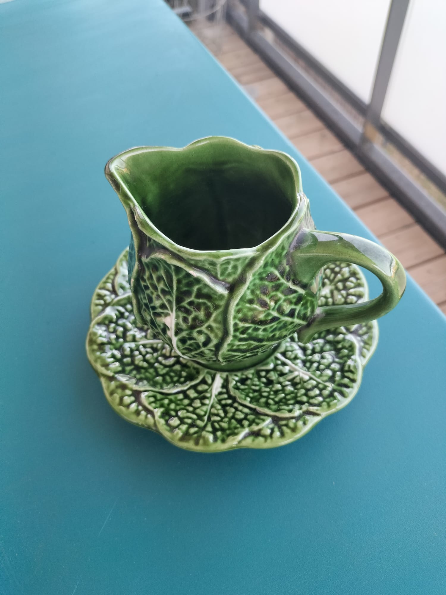 Vintage milk jug with cabbage leaf design in majolica with saucer.