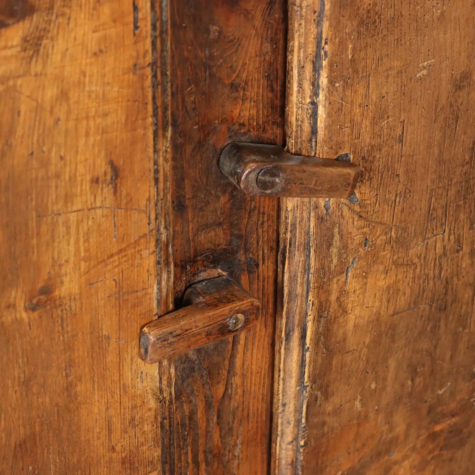 Antique pine wardrobe painted in walnut stain, restorations, Italy, 17th century.