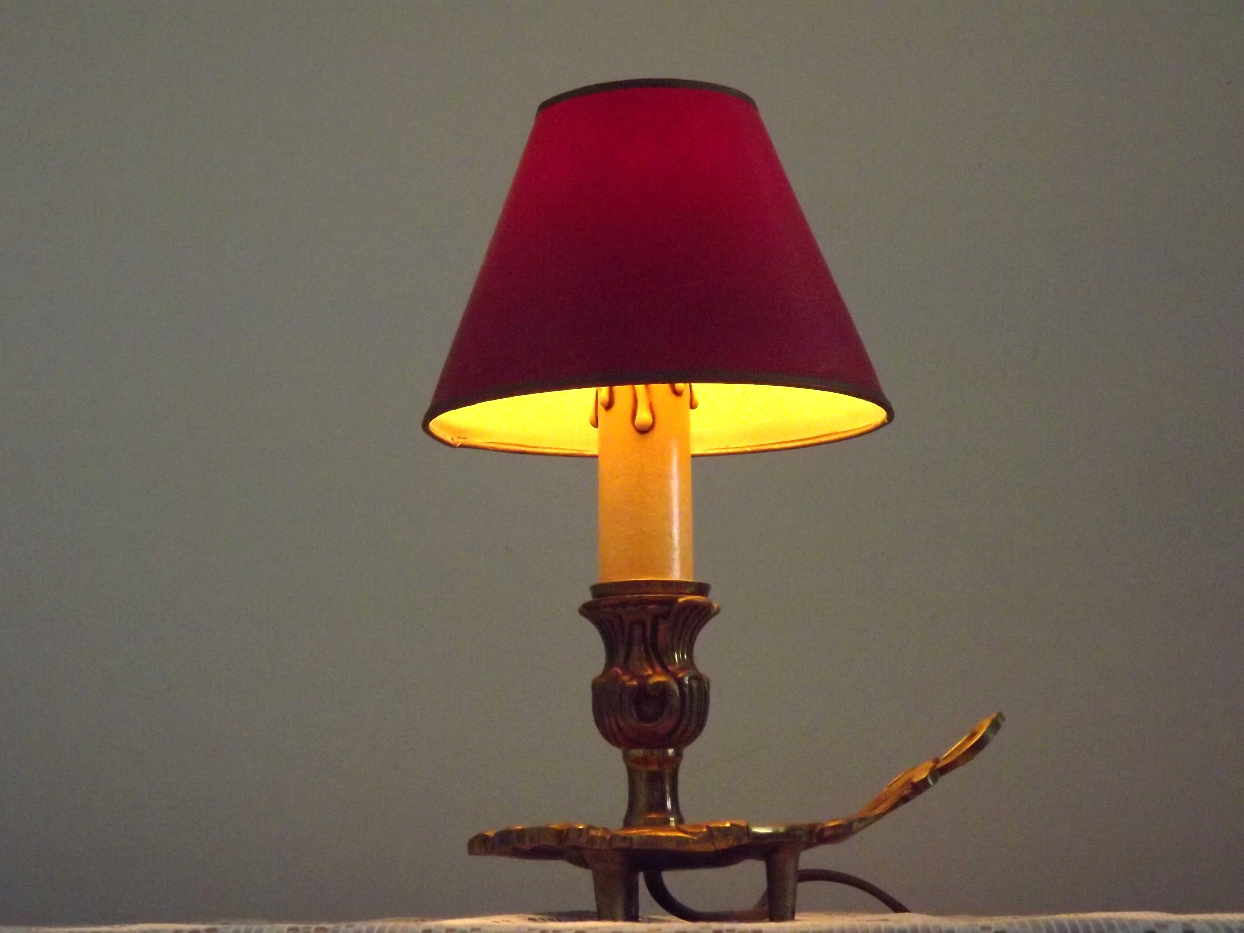 Vintage French bronze Wee Willie Winkie style lamp with red card shade.