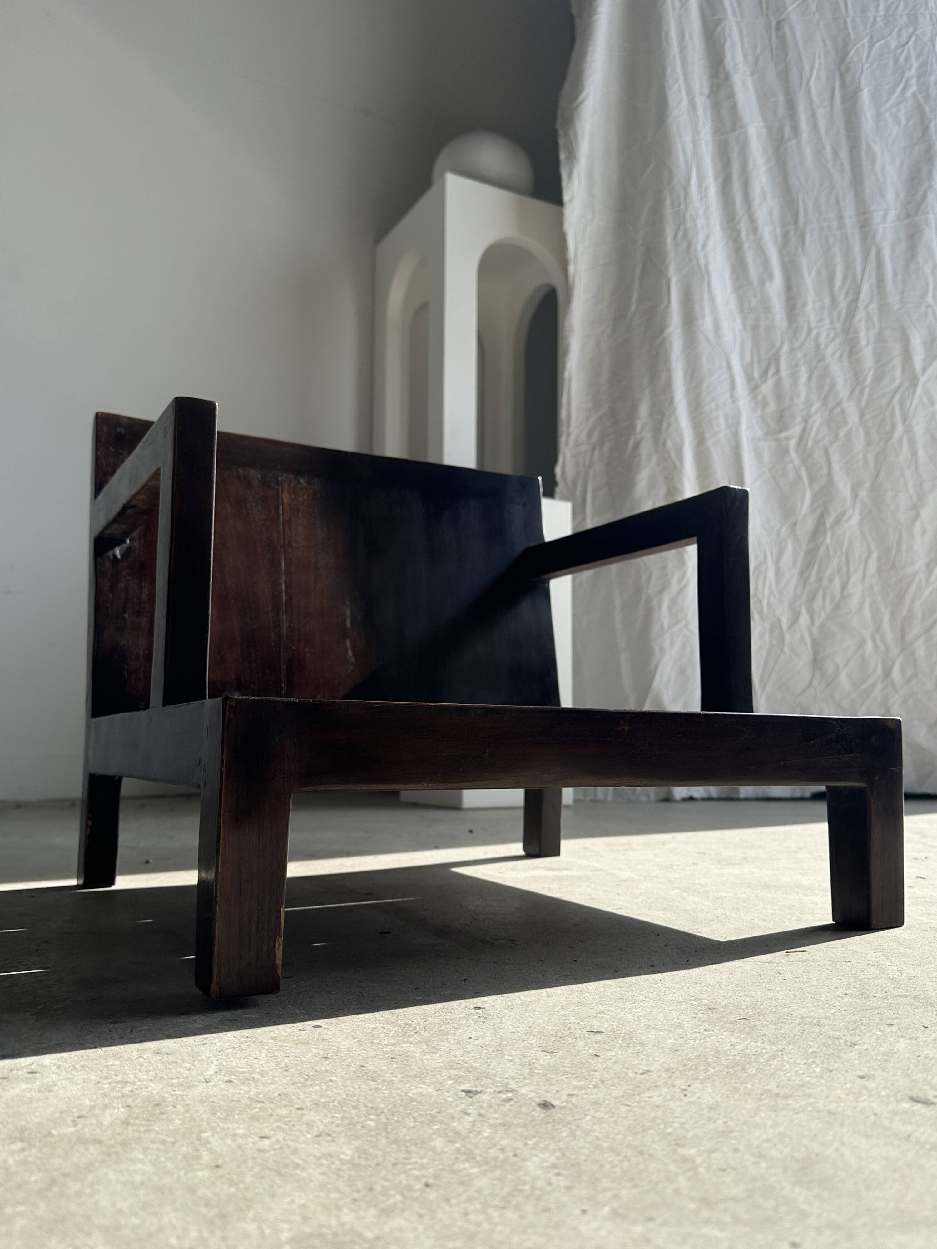 Small low armchair in varnished brown wood