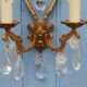 French antique Louis XV style twin arm wall sconces in bronze with crystals.