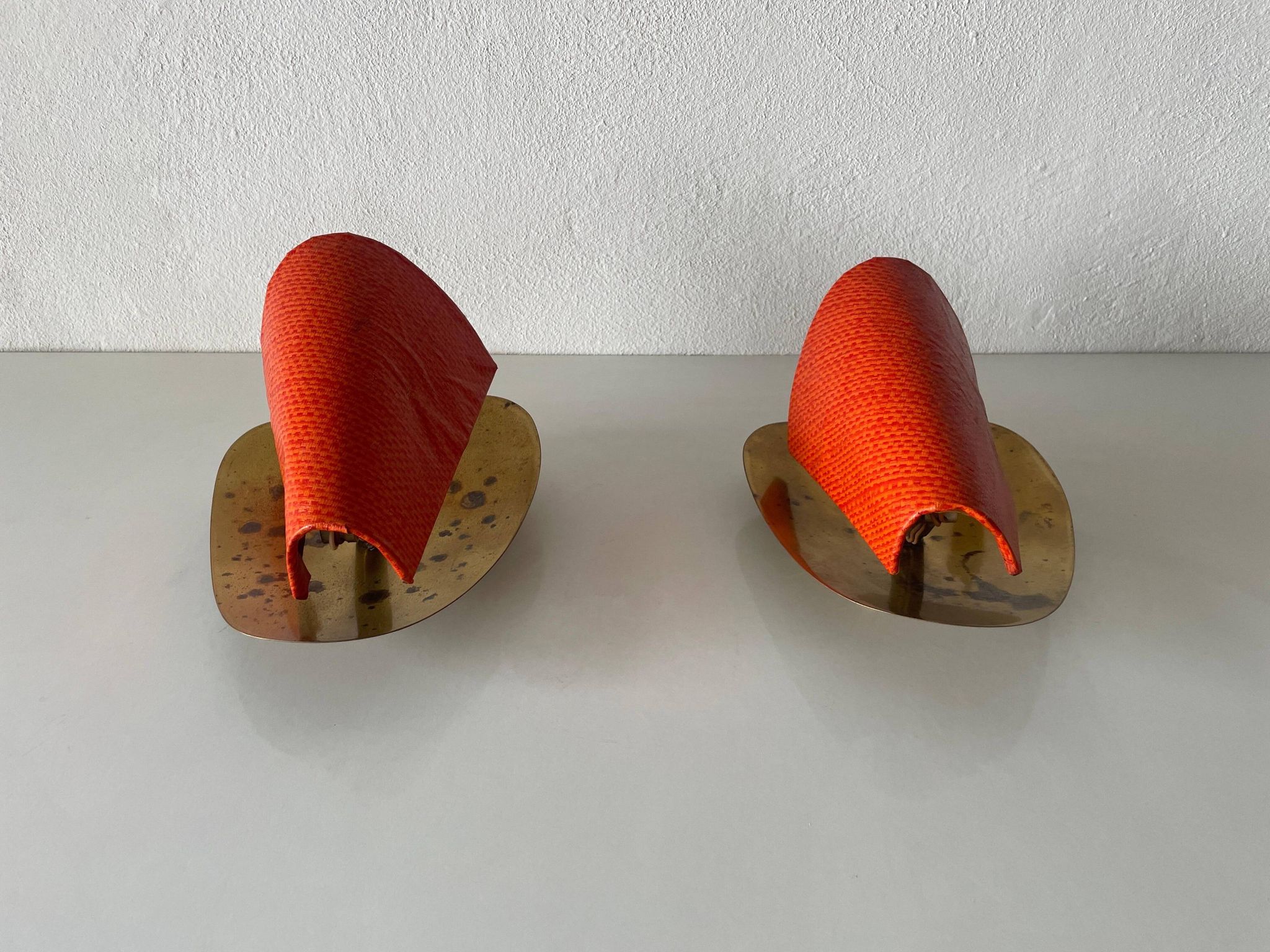 Pair of orange plexiglass and curved brass wall lights, 1950s, Germany