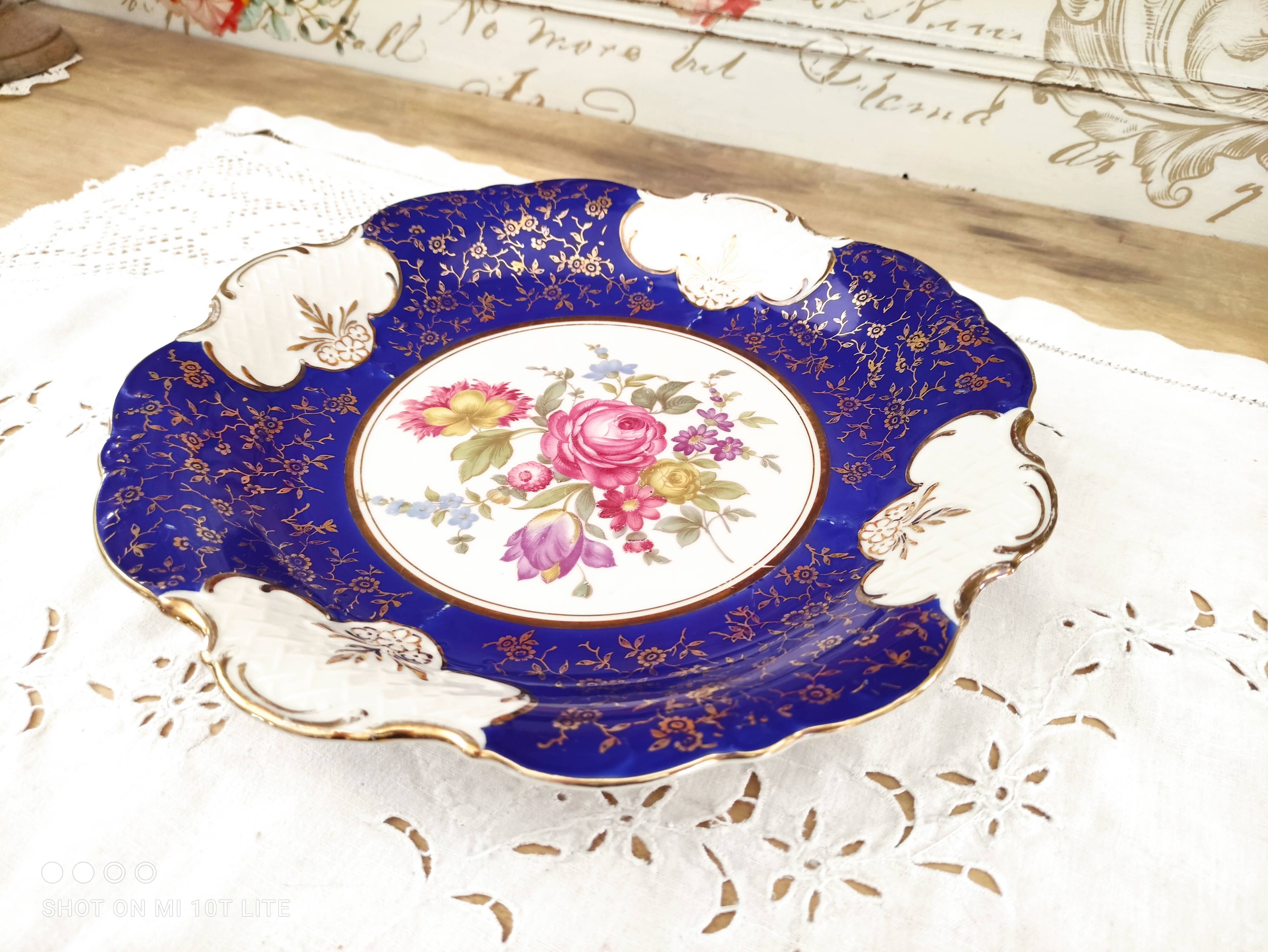 Plat rond creux en porcelaine allemande bleu nuit et motifs floraux polychromes et dorés