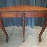 Half-moon mahogany game table on casters