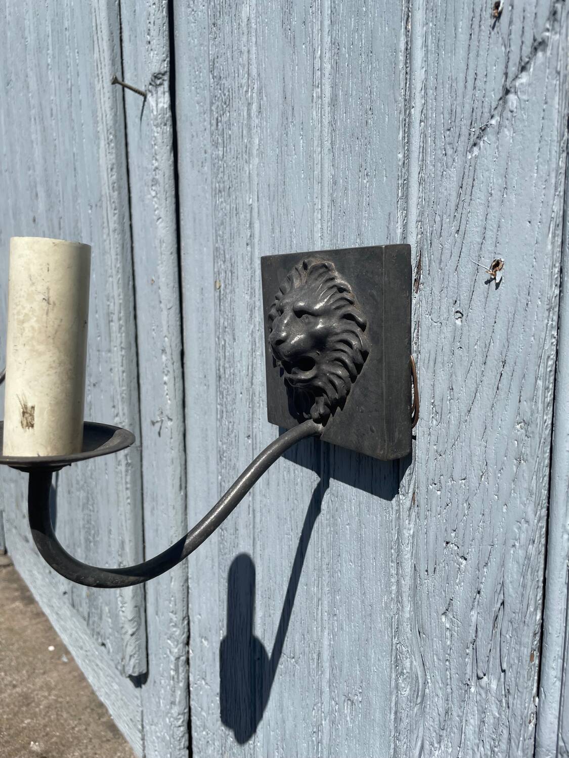 Two lion head wall sconces in tin.