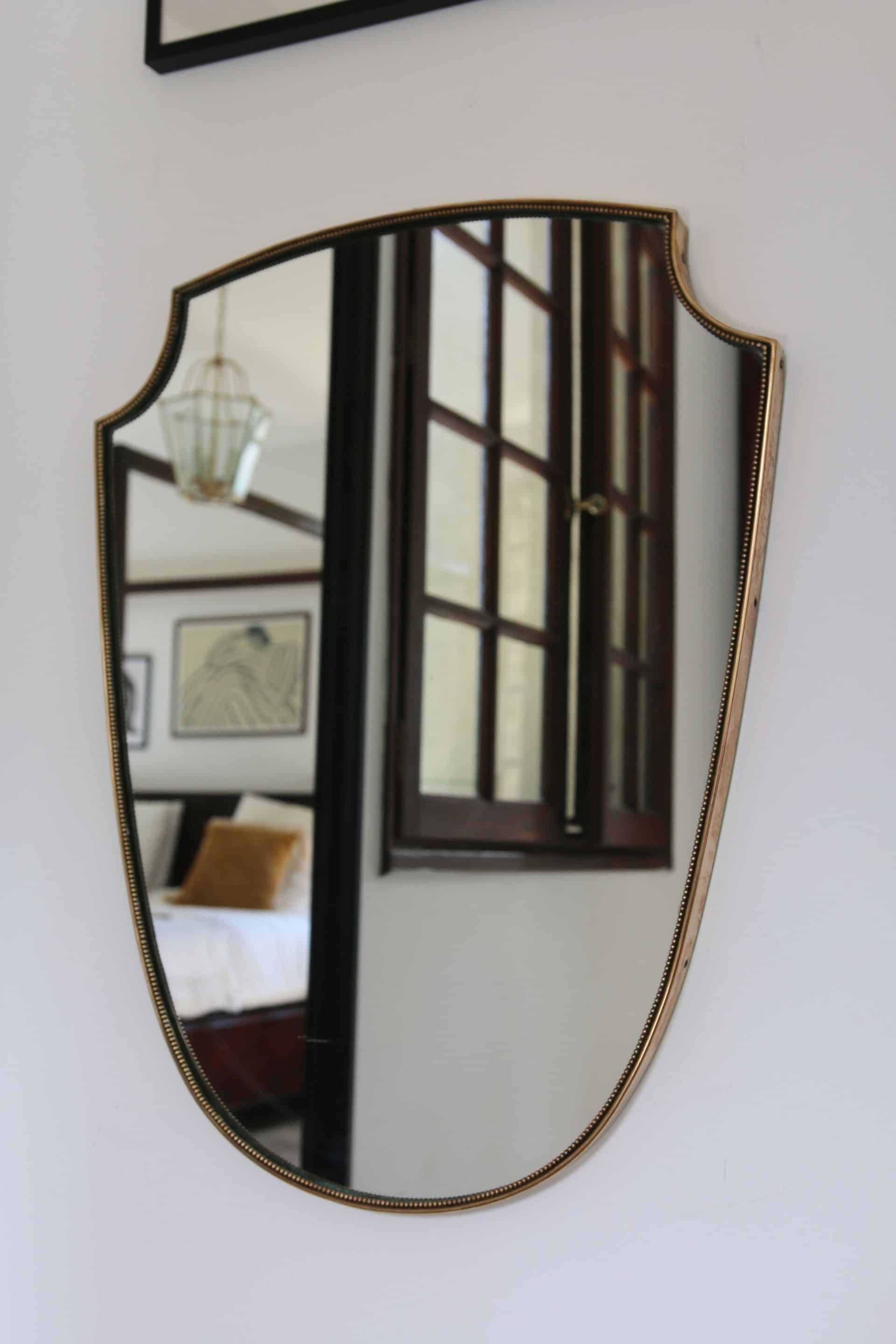 Brass mirror with crest, bead frieze, Italian design style.