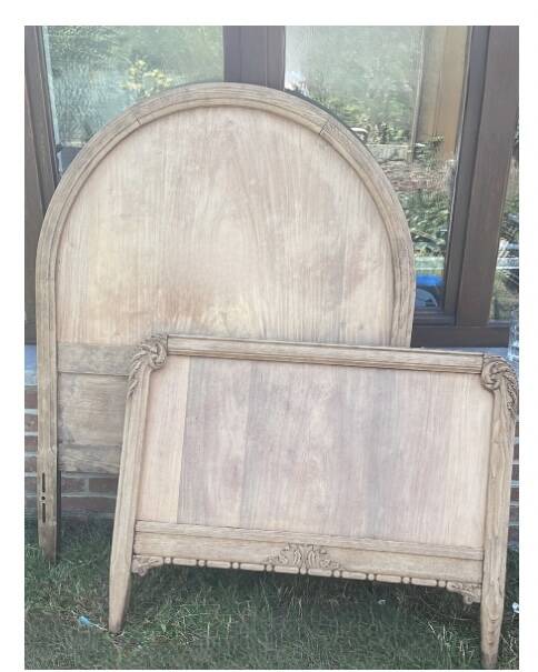 Antique solid wood bed with a carved rounded headboard — Louis XV style