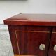 1950s bedside table in varnished wood veneer and brass.